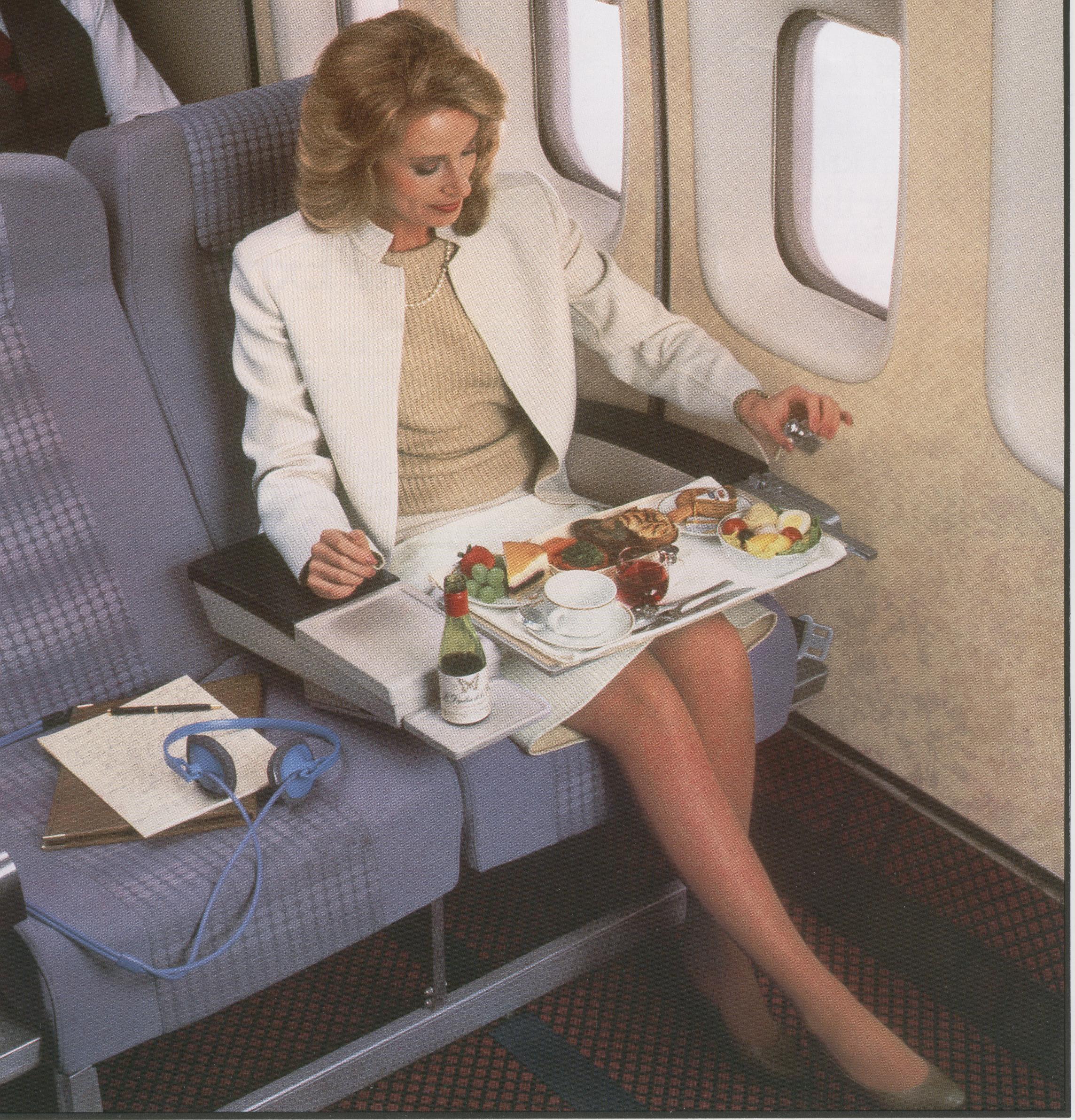 1980s A customer enjoying a meal in Pan Am's Clipper Class (business class) on a Boeing 747.  Pan Am's first Clipper Class Cabins offered 8 across seating instead of the 10 across in Economy class.